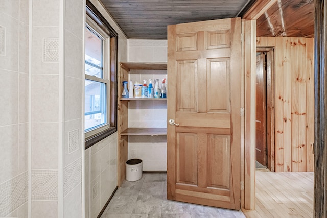 interior space featuring tile walls, wooden ceiling, and wood walls