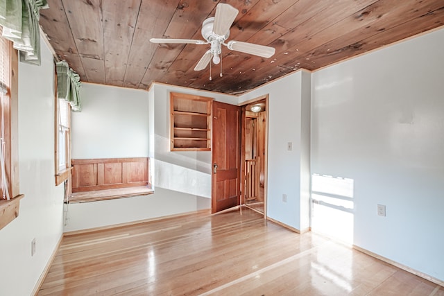 empty room with ceiling fan, wood ceiling, and light wood-type flooring