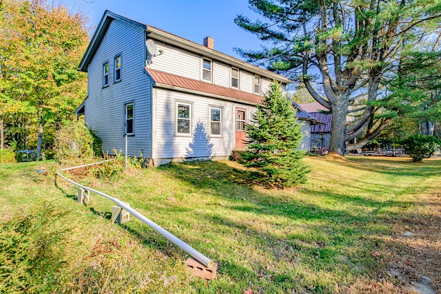 rear view of property with a lawn