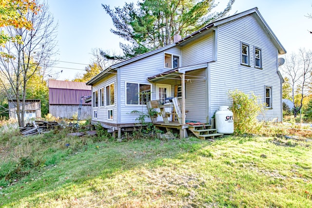 rear view of property featuring a storage shed and a lawn