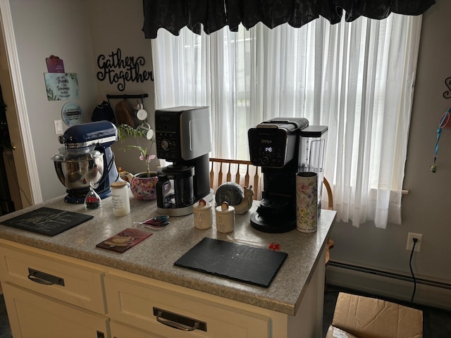 kitchen with a baseboard heating unit, cream cabinets, and a healthy amount of sunlight