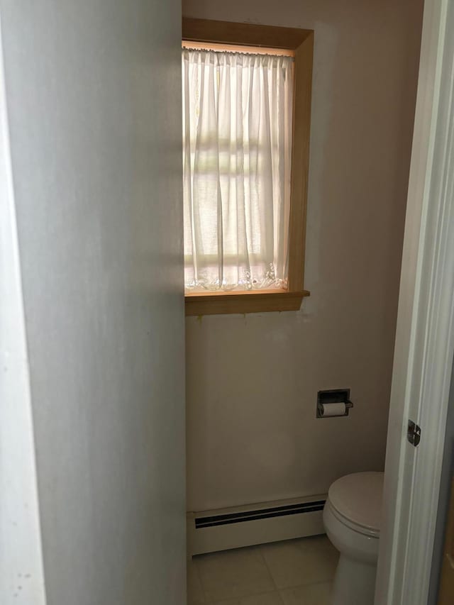 bathroom with tile patterned flooring, a baseboard heating unit, and toilet