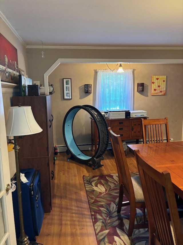 dining space featuring hardwood / wood-style flooring and crown molding