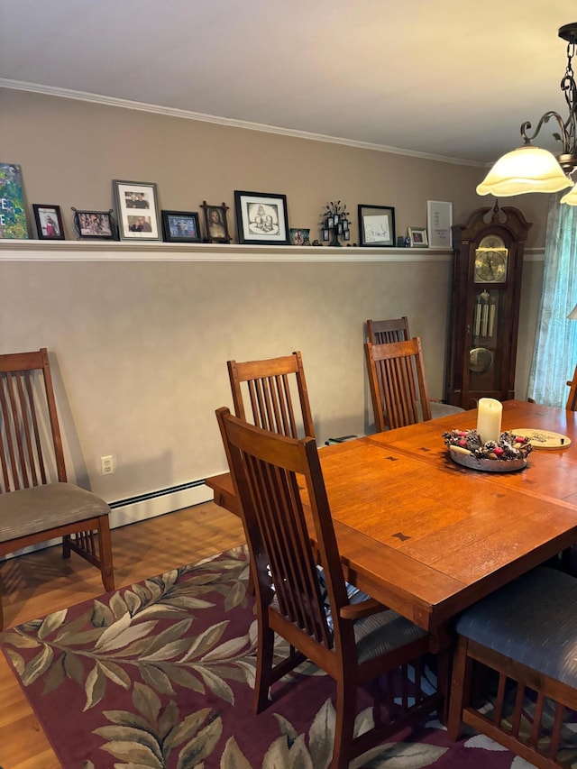 dining area featuring crown molding, hardwood / wood-style flooring, and a baseboard radiator