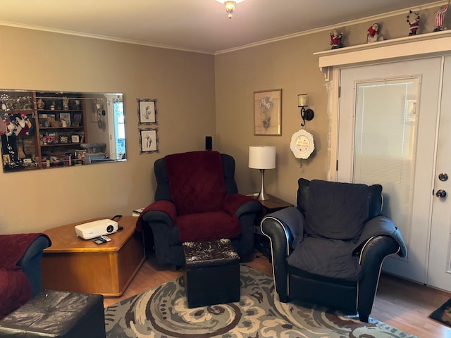 sitting room with wood-type flooring and ornamental molding