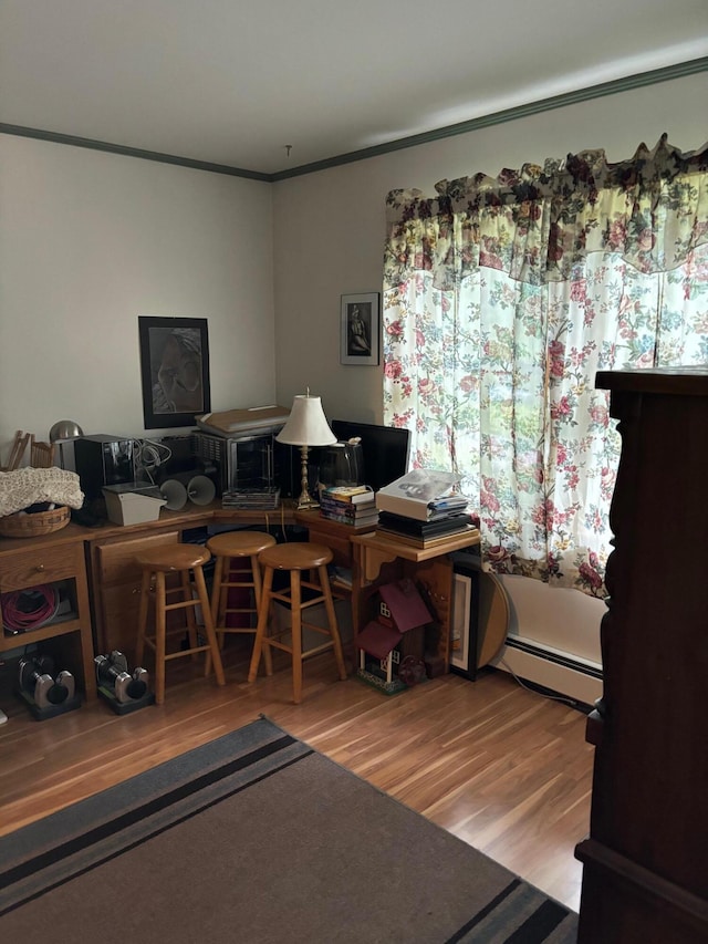 office space with baseboard heating, crown molding, and hardwood / wood-style floors