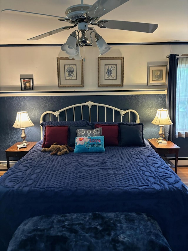 bedroom featuring ceiling fan, a baseboard radiator, and hardwood / wood-style floors