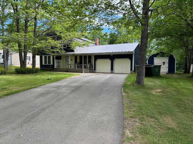 ranch-style house featuring covered porch, a front lawn, a garage, and a shed