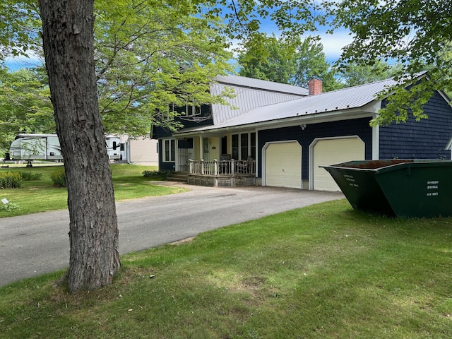 view of front of home with a garage, covered porch, and a front lawn