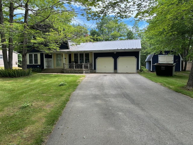 view of front of property with a garage, covered porch, and a front yard