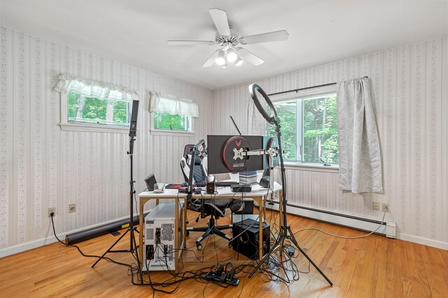 home office featuring wood-type flooring, a baseboard radiator, and ceiling fan