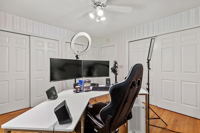 home office with ceiling fan and light hardwood / wood-style flooring