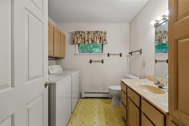 washroom with a baseboard heating unit, independent washer and dryer, and sink