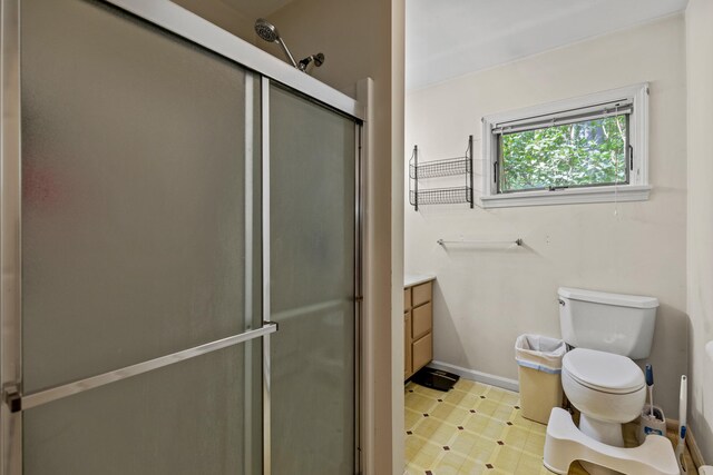 bathroom featuring walk in shower, toilet, and vanity