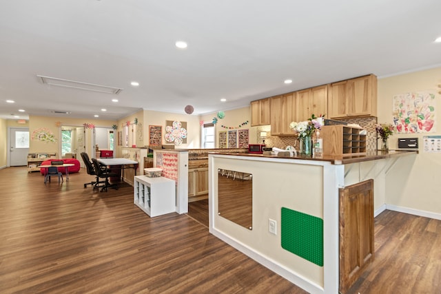 kitchen with backsplash, light brown cabinets, dark hardwood / wood-style floors, kitchen peninsula, and ornamental molding