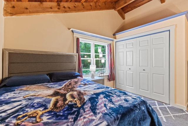 bedroom with a closet, lofted ceiling with beams, and carpet floors