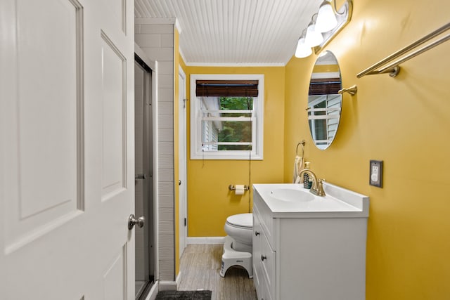 bathroom with a shower with shower door, hardwood / wood-style floors, toilet, and vanity