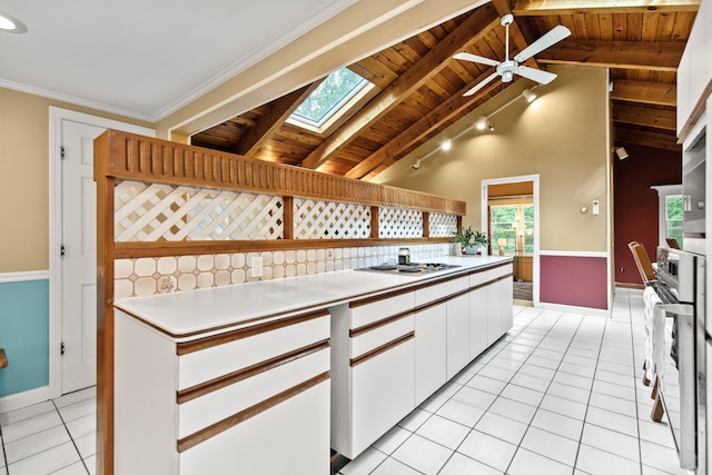 kitchen featuring white cabinets, ceiling fan, vaulted ceiling with skylight, and wooden ceiling