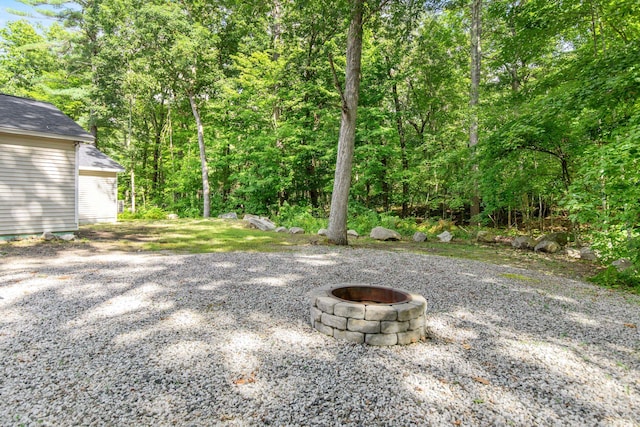 view of yard featuring an outdoor fire pit, a garage, and an outbuilding