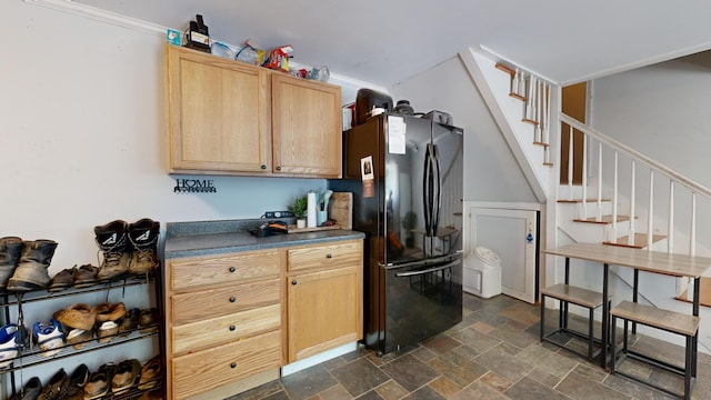 kitchen with crown molding, black refrigerator, and light brown cabinets
