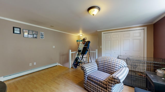 sitting room featuring light wood-type flooring, crown molding, and a baseboard heating unit