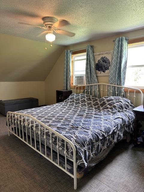 bedroom featuring carpet, a textured ceiling, ceiling fan, and cooling unit