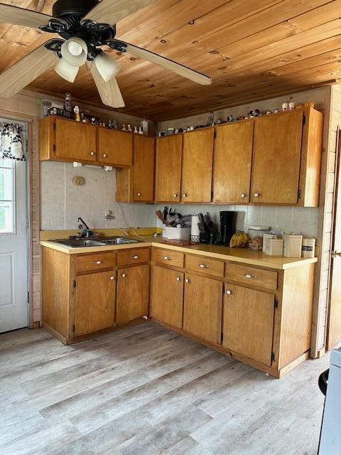 kitchen with ceiling fan, wood ceiling, sink, and light hardwood / wood-style flooring