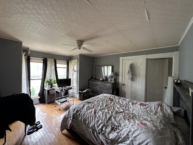 bedroom with crown molding, light hardwood / wood-style floors, and ceiling fan