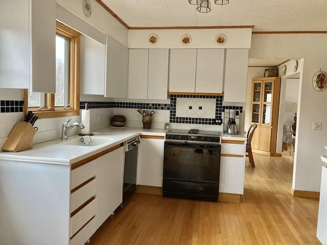 kitchen with light hardwood / wood-style floors, decorative backsplash, black appliances, white cabinets, and sink