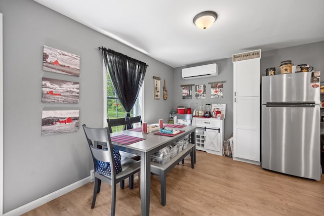 dining room with a wall mounted air conditioner and light wood-type flooring