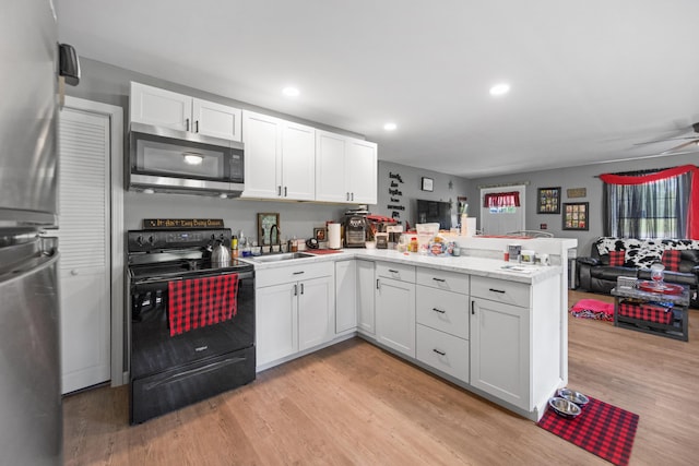 kitchen featuring kitchen peninsula, stainless steel appliances, white cabinets, and light hardwood / wood-style flooring