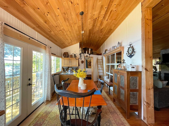 dining room with vaulted ceiling, wood-type flooring, an inviting chandelier, french doors, and wooden ceiling