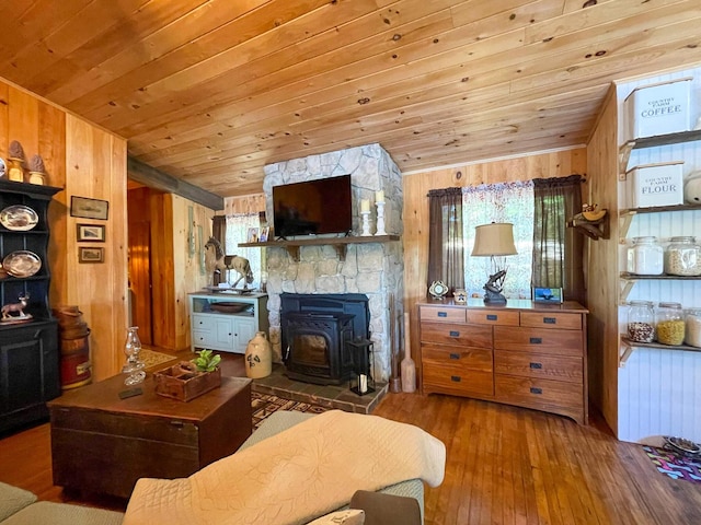 living room with wood ceiling, a wood stove, wood-type flooring, and wooden walls