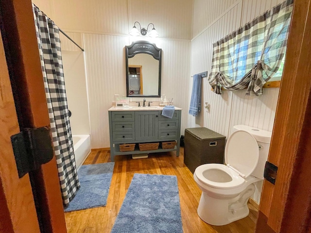 full bathroom with wood-type flooring, toilet, vanity, and shower / bath combination with curtain