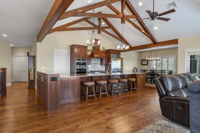 kitchen featuring ceiling fan with notable chandelier, light stone countertops, decorative backsplash, hanging light fixtures, and dark hardwood / wood-style floors