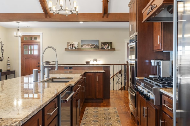 kitchen with an inviting chandelier, appliances with stainless steel finishes, light stone counters, and sink