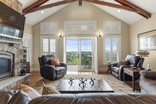 living room featuring light wood-type flooring, a wealth of natural light, a fireplace, and lofted ceiling with beams