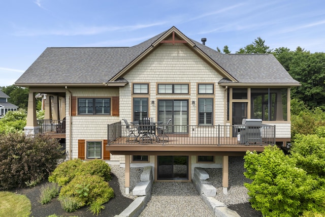 rear view of property featuring a deck and a sunroom