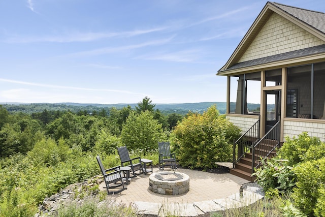 view of patio with a sunroom and a fire pit