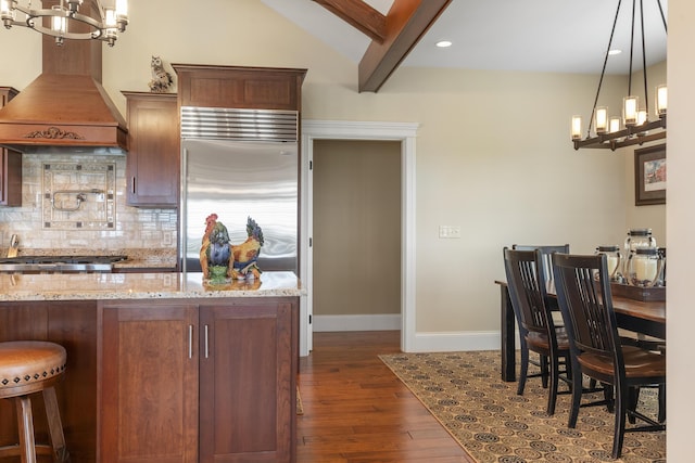 kitchen featuring custom exhaust hood, tasteful backsplash, pendant lighting, light stone counters, and beamed ceiling