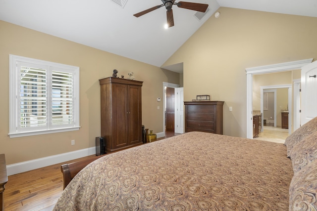 bedroom with ensuite bath, ceiling fan, high vaulted ceiling, and light hardwood / wood-style flooring