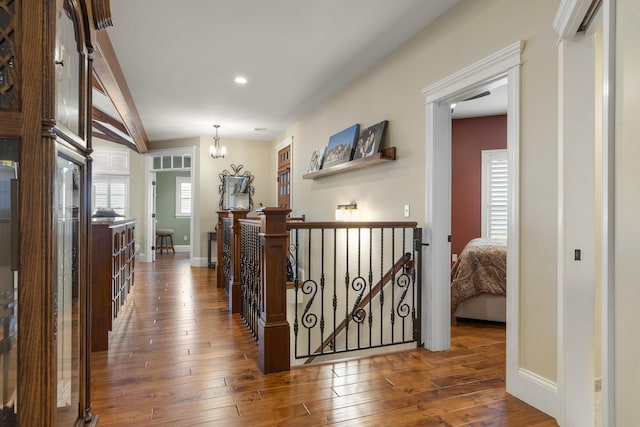 hall with vaulted ceiling, dark hardwood / wood-style floors, and a chandelier