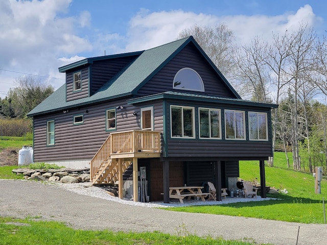 back of property featuring a sunroom and a lawn