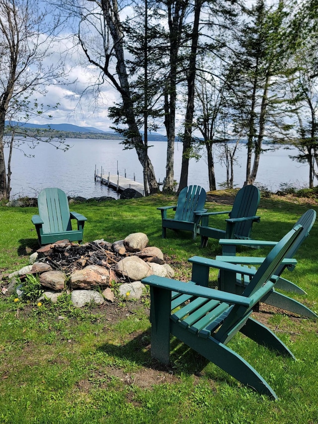 view of property's community with a boat dock, a water and mountain view, and a lawn