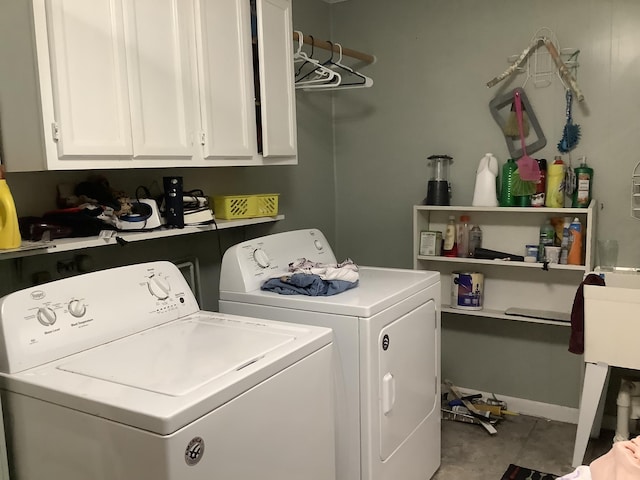 washroom featuring cabinets, light tile patterned floors, and washer and clothes dryer