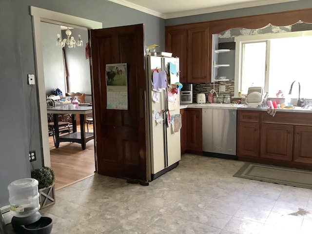 kitchen featuring sink, stainless steel dishwasher, backsplash, crown molding, and a chandelier