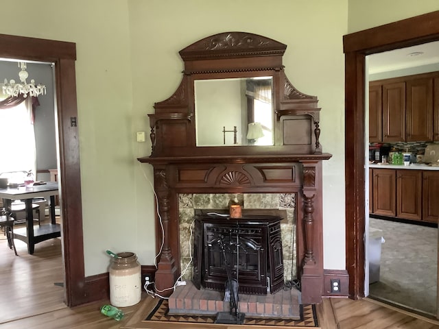 room details featuring a wood stove, hardwood / wood-style floors, and a notable chandelier