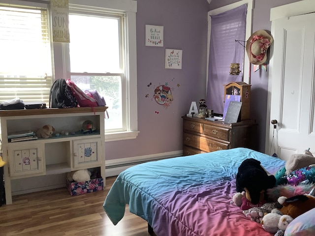 bedroom with light hardwood / wood-style floors and multiple windows