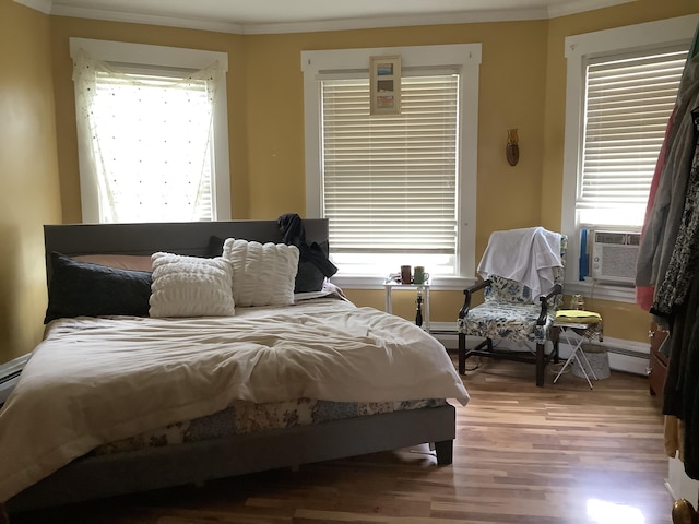 bedroom featuring hardwood / wood-style floors, cooling unit, and crown molding