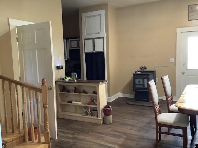 interior space with a wood stove and dark wood-type flooring